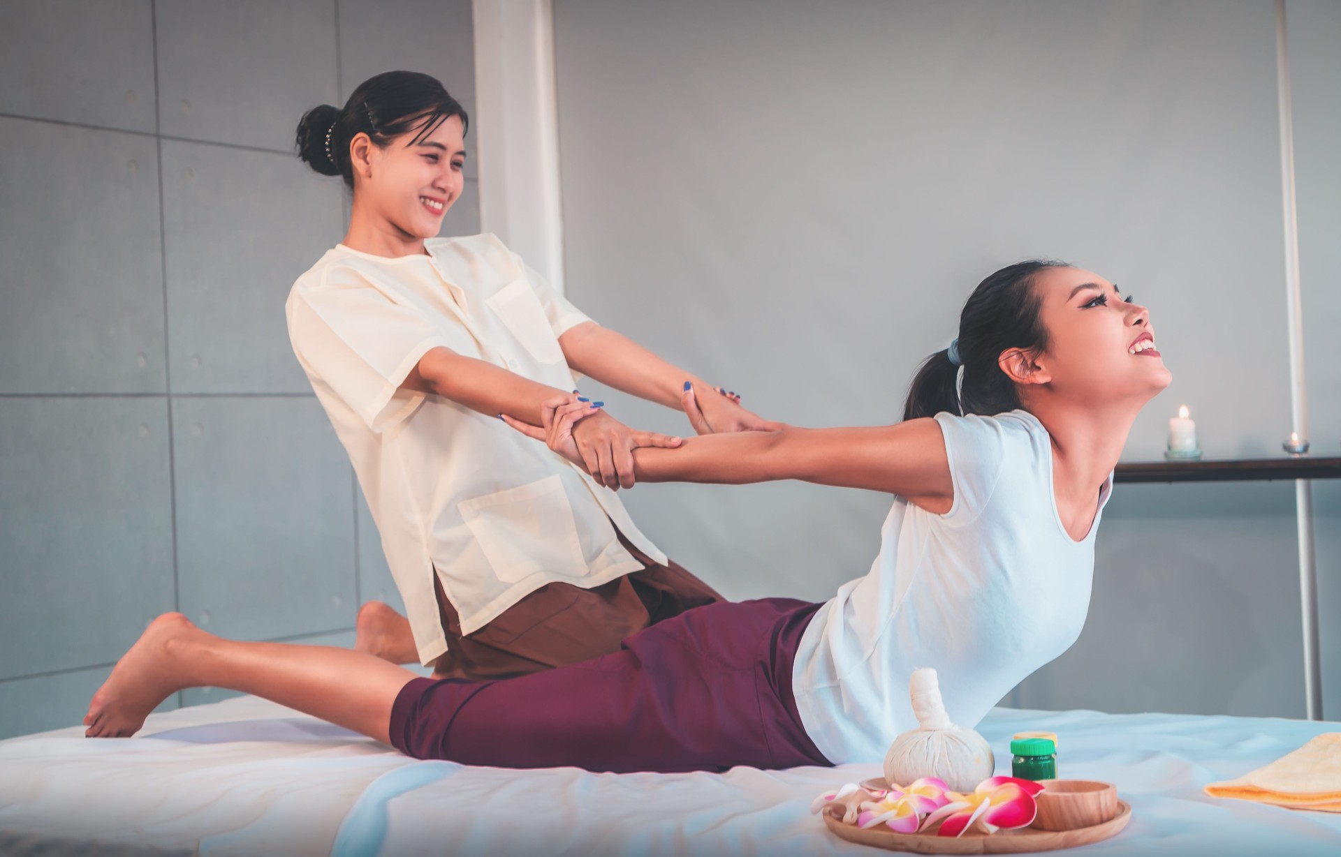Woman is receiving Back Massage Stretching in Thai Therapy Spa treament.